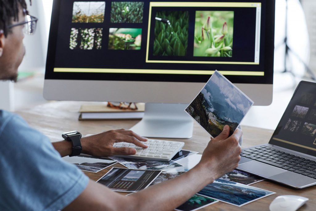 Photographer editing aerial shots on a computer, refining work created with affordable used drones for aerial photography in 2025.