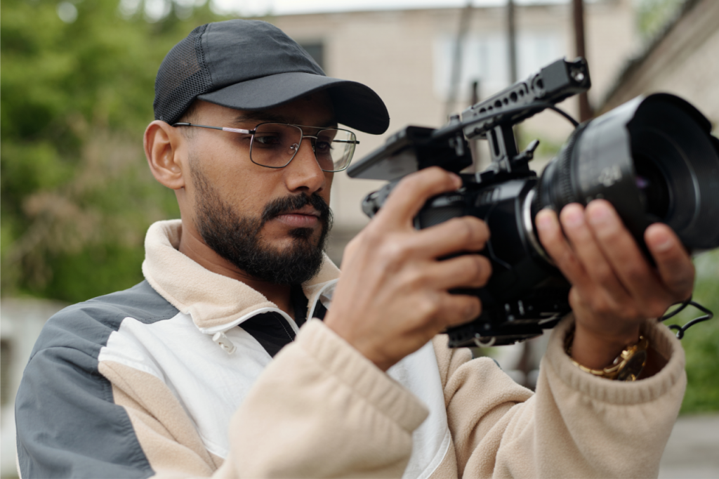 Close-up of a filmmaker holding a professional cinema camera, symbolizing the shift toward next-gen tools like the RED V-RAPTOR-XE.