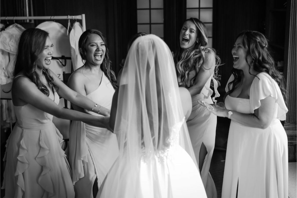 Bride laughing with her bridesmaids before the ceremony, captured to highlight the joy delivered through same-day wedding photo edits.