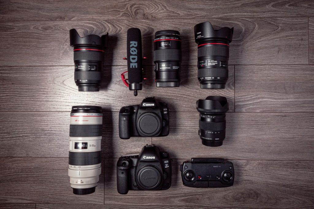 A flat lay of cameras, lenses, and a microphone arranged neatly on a wood floor, showing Why Smart Creators Are Listing Before Everyone Else to maximize Black Friday visibility.