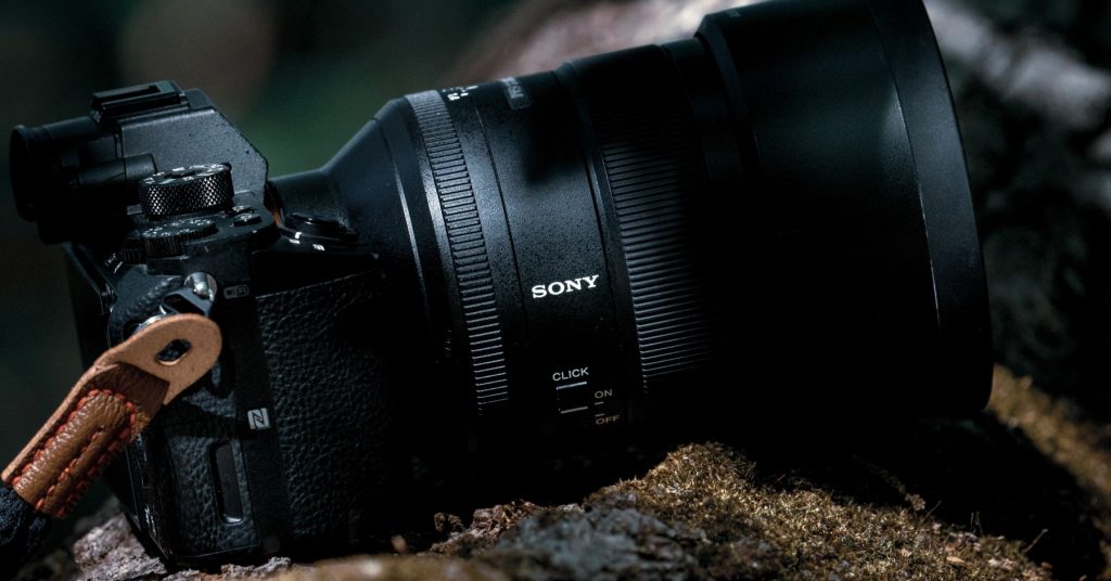 Close-up of a Sony mirrorless camera resting on a forest log, ideal for Black Friday deals for creators looking for pro-level used gear.
