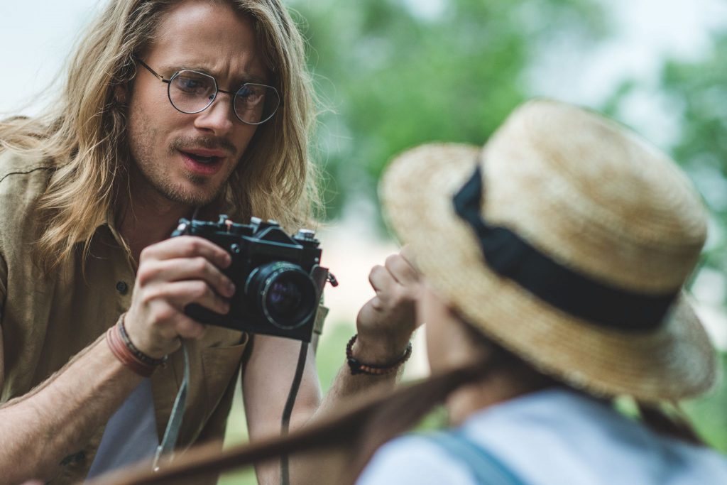 A photographer connecting with a subject during an outdoor shoot — the human relationship at the center of casting photography and portrait work