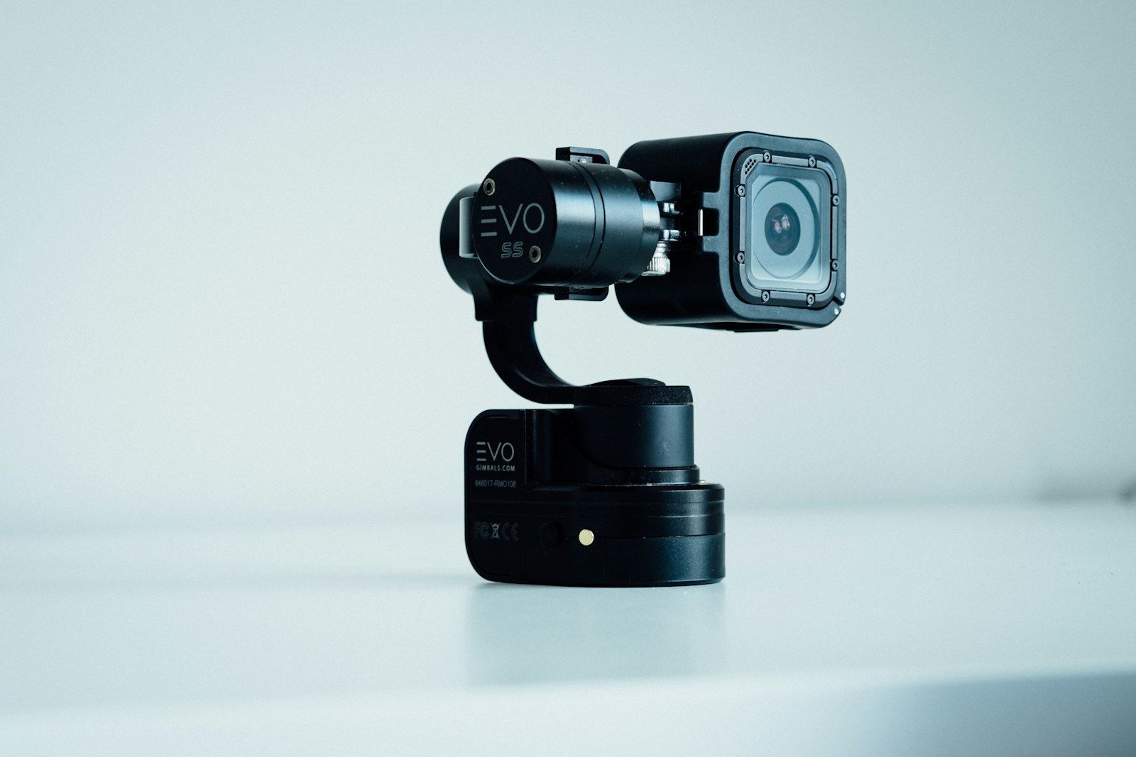 compact gimbal camera with mounted action camera on a white table