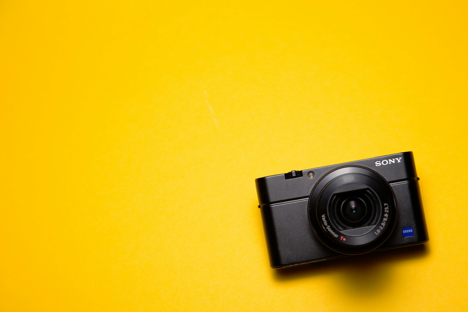black Sony point-and-shoot camera on a yellow surface