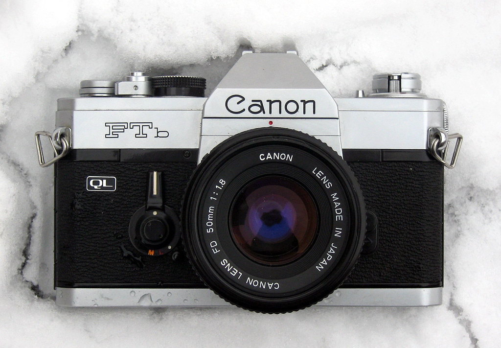 vintage Canon FTb QL 35mm SLR camera with 50mm lens on a marble surface